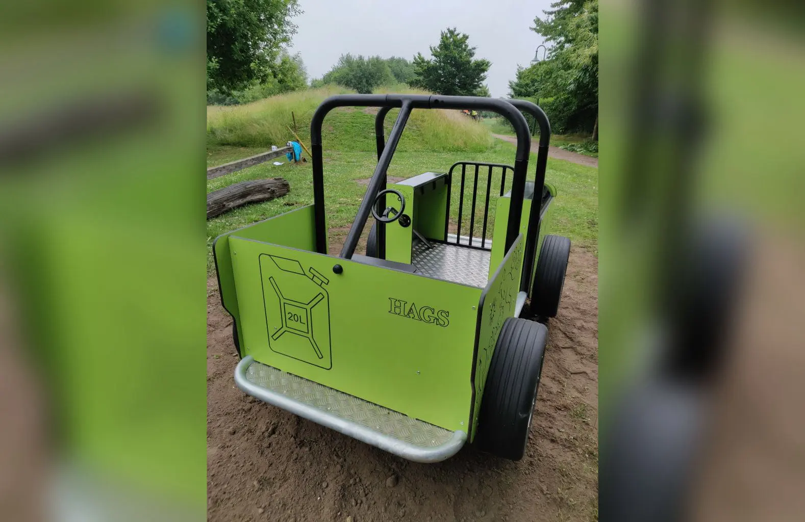 Grünes Spielgerät in Jeep-Form auf Sandfläche