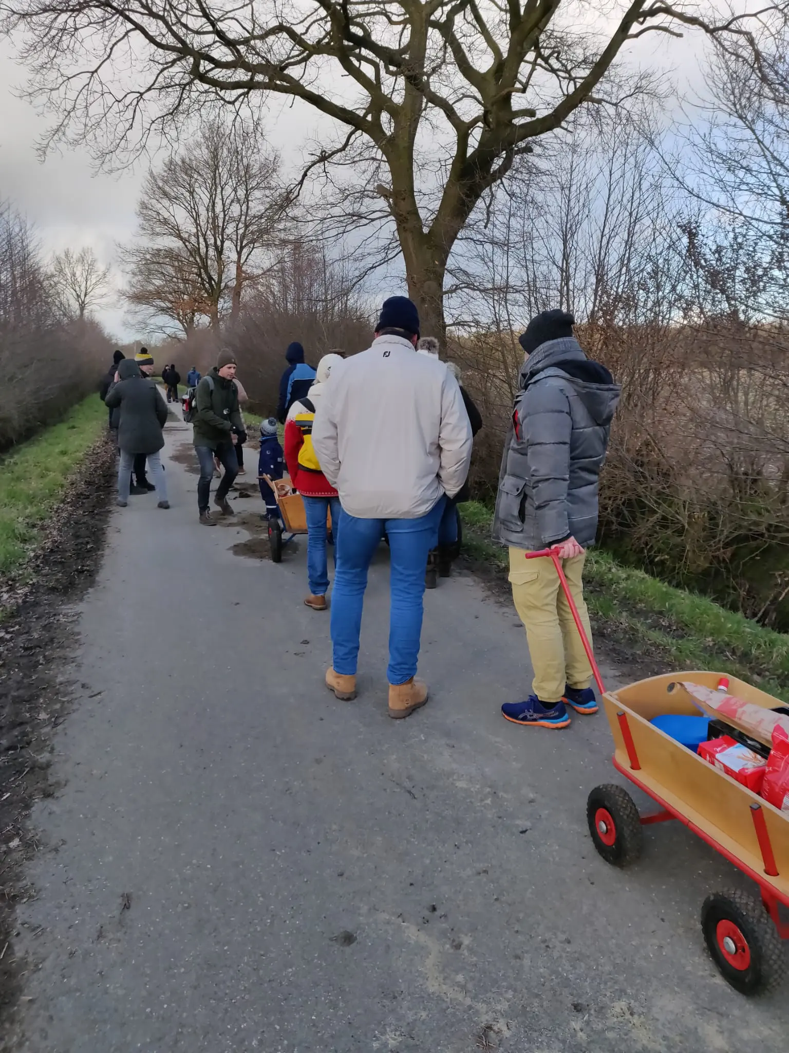 Gruppe mit Bollerwagen auf einem Feldweg
