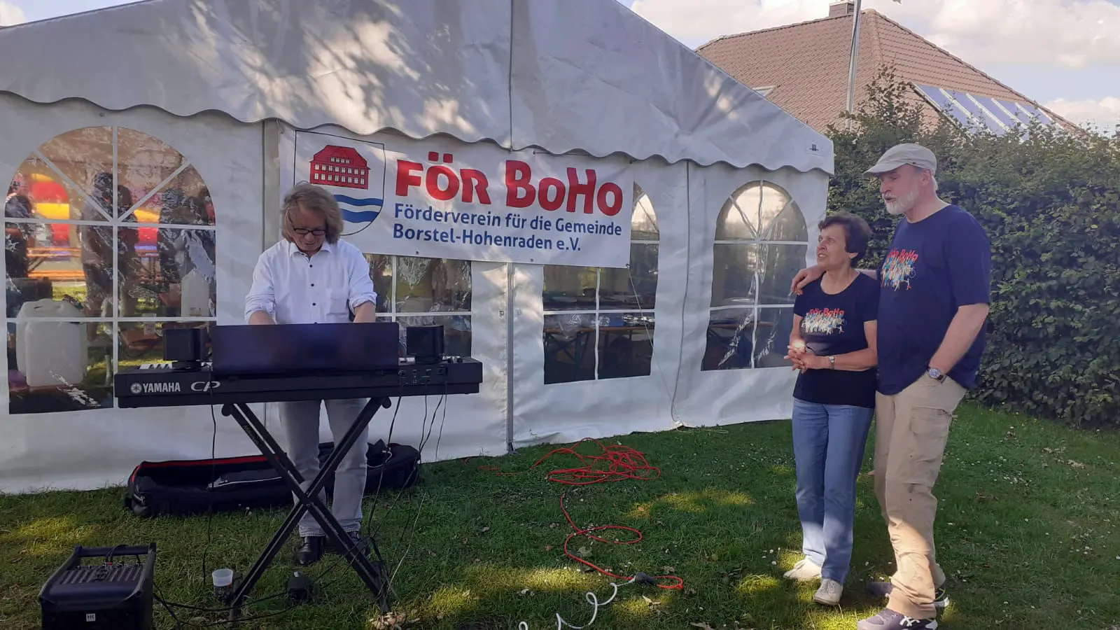 Musiker an einem Keyboard im Festzelt mit För-BoHo-Banner