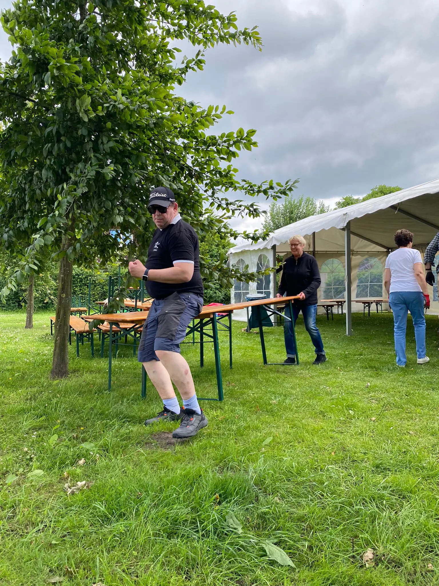 Mann auf der Wiese vor Biertischen und Festzelt