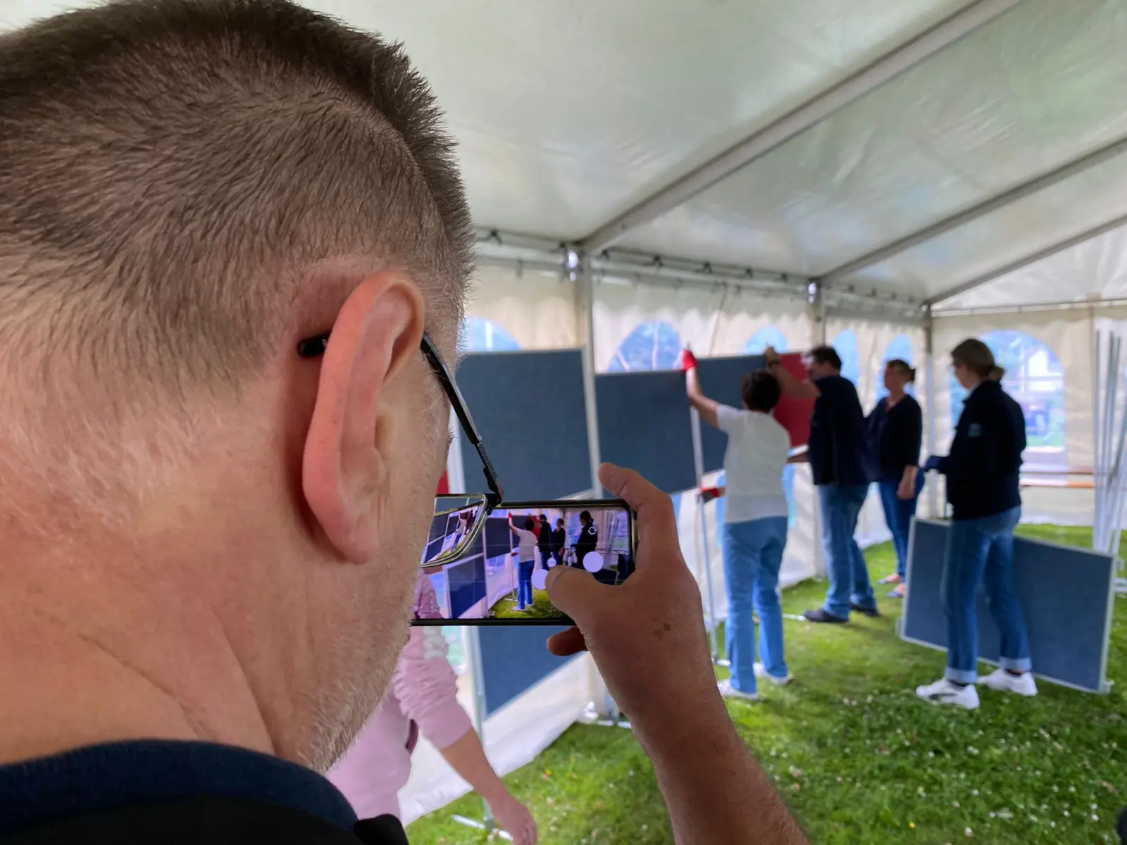 Mann fotografiert mit dem Smartphone im Festzelt