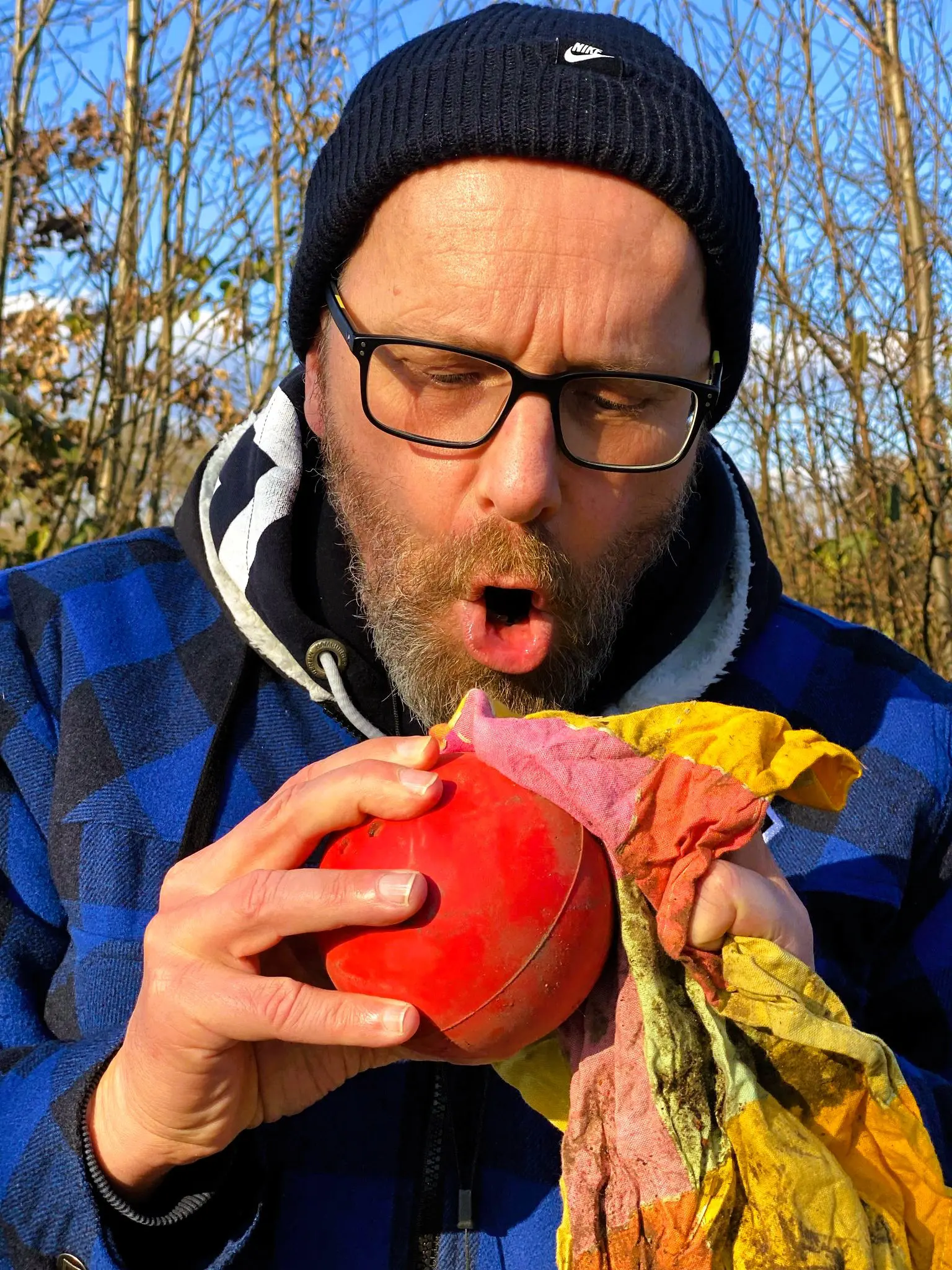 Teilnehmer mit Strickmütze beißt in eine rote Kugel
