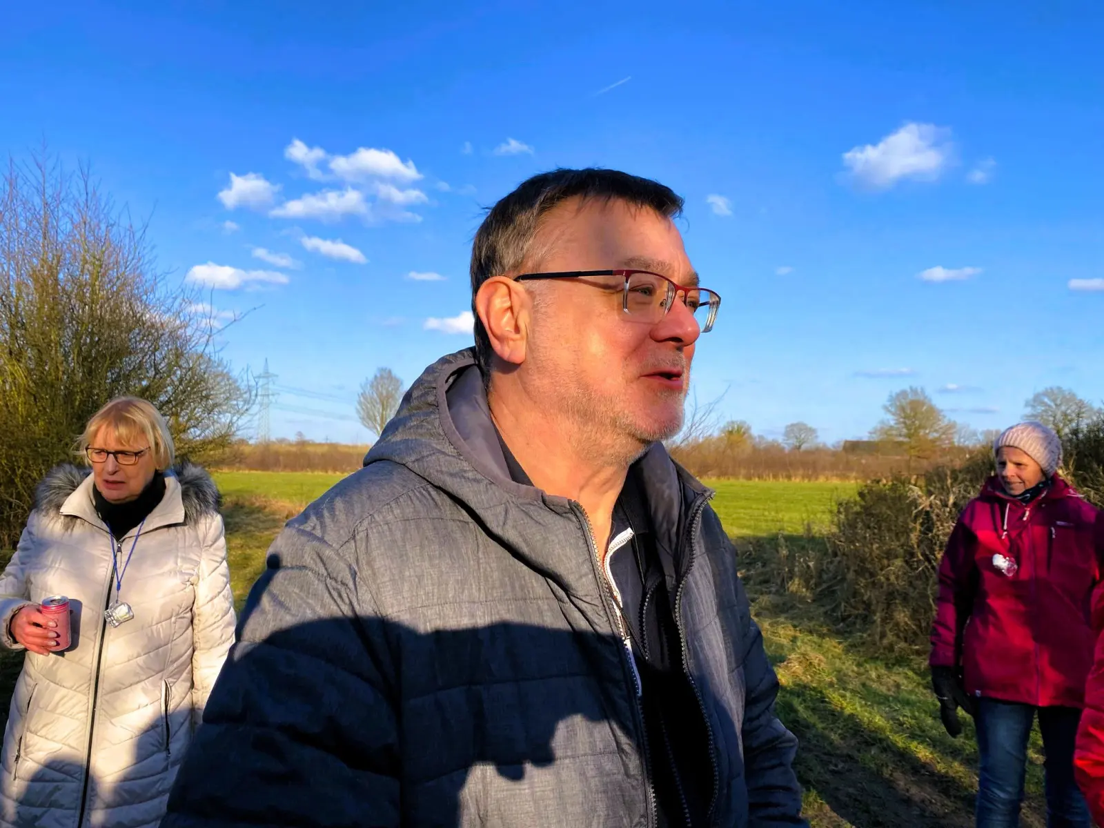 Teilnehmer der Boßeltour im Gespräch auf einem Feldweg
