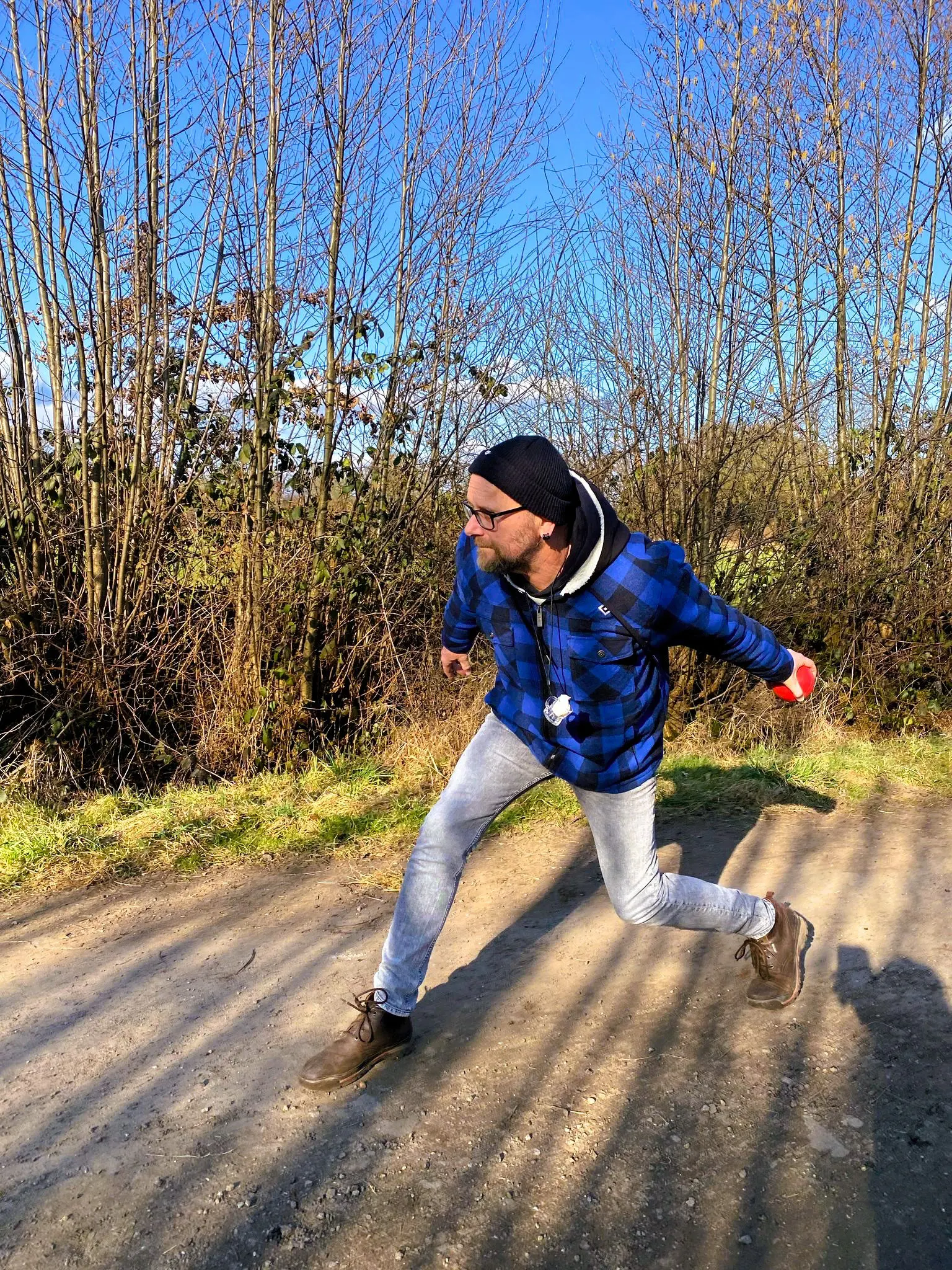 Teilnehmer wirft die Boßelkugel auf dem Feldweg