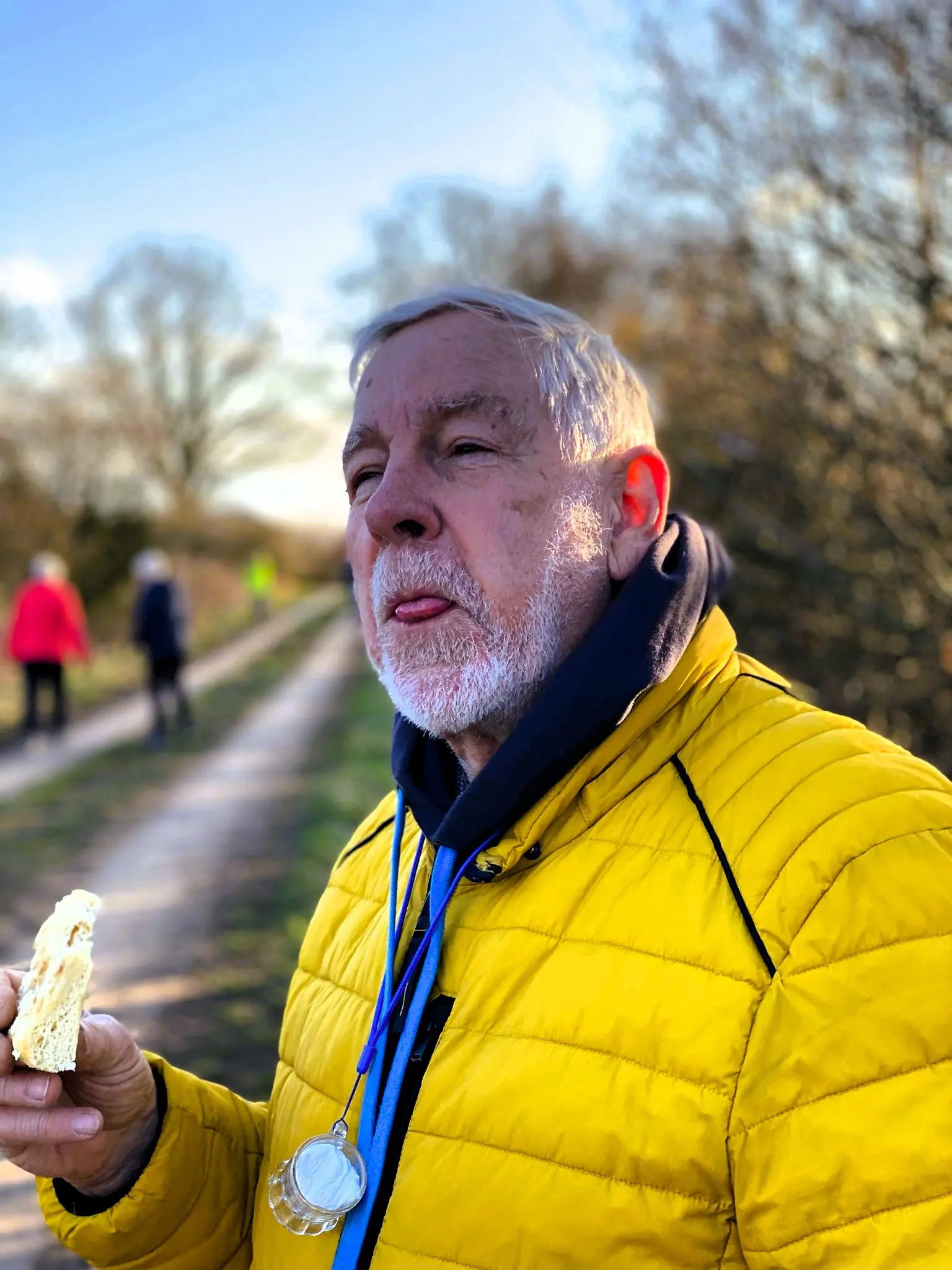 Teilnehmer in gelber Jacke mit einem Snack