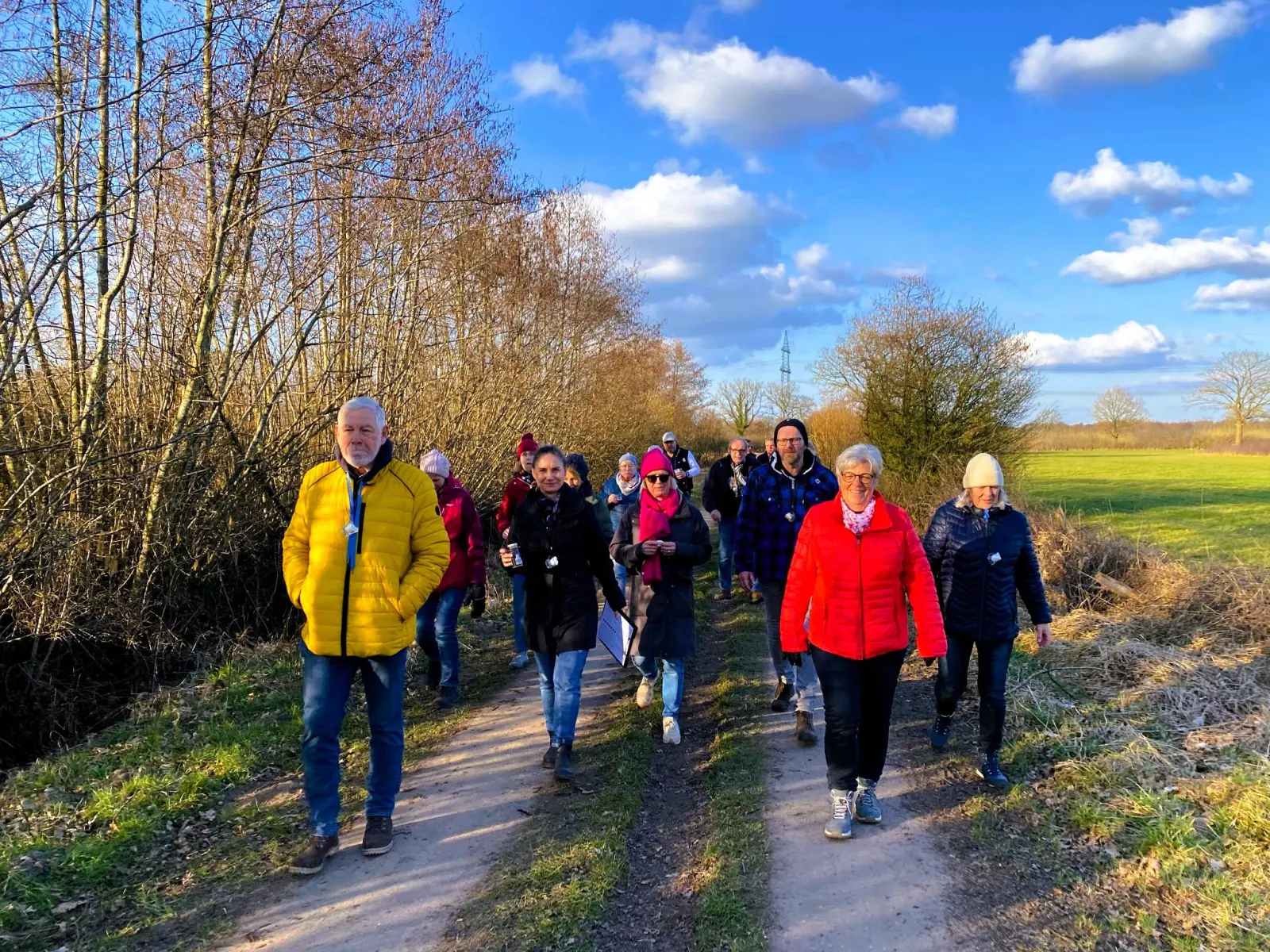 Wandergruppe auf dem Weg an einem Feld