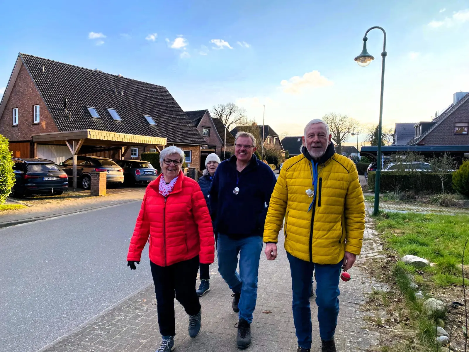 Drei Teilnehmende gehen die Dorfstraße entlang
