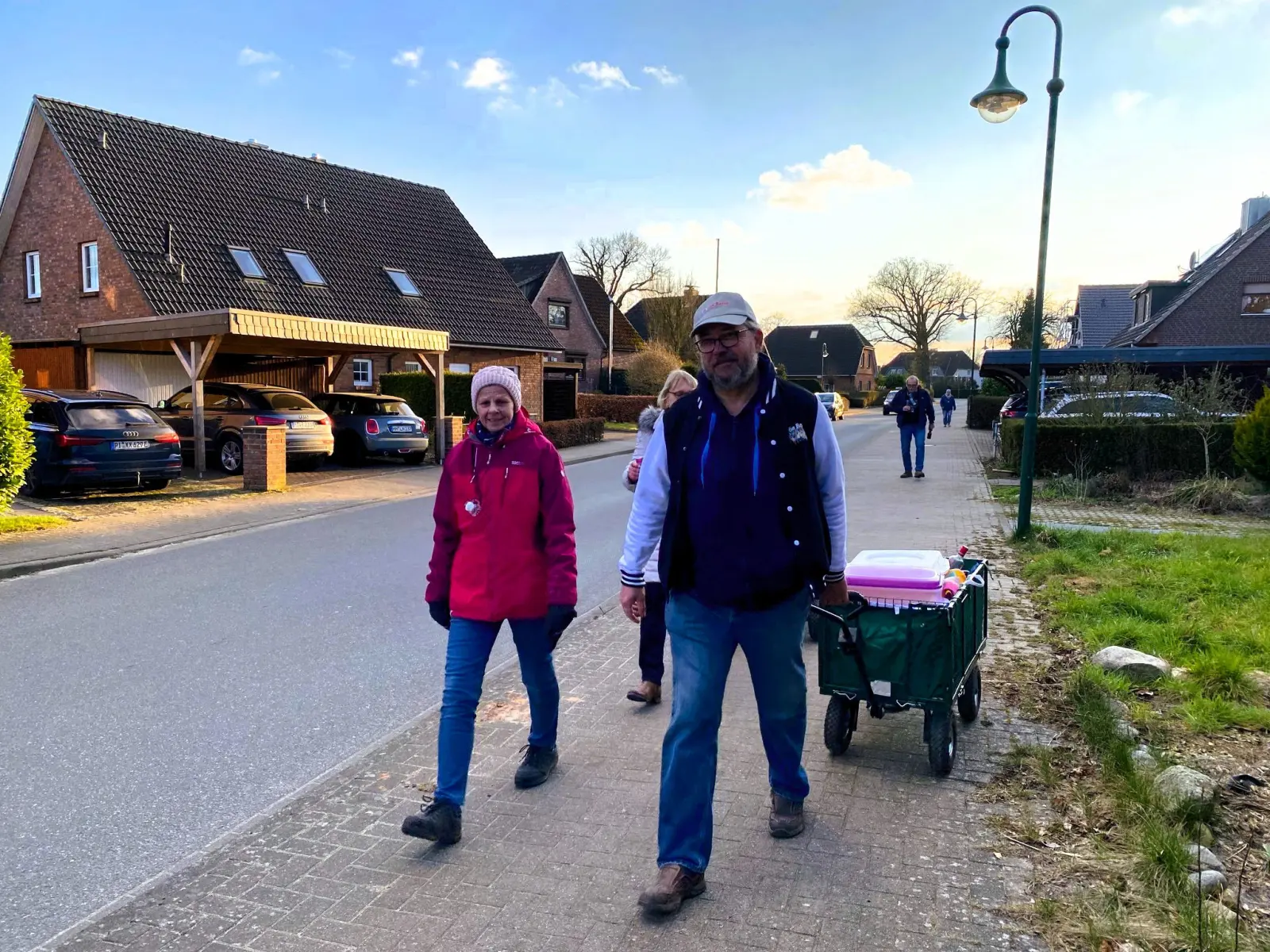 Zwei Teilnehmende mit Bollerwagen auf der Dorfstraße